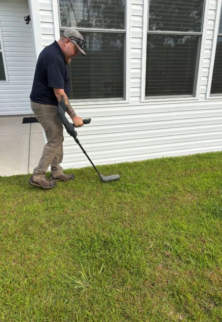 termite-treatment-bait-traps-columbia-sc-pest-control Jeffcoat tech using ground detector to install termite bait stations.