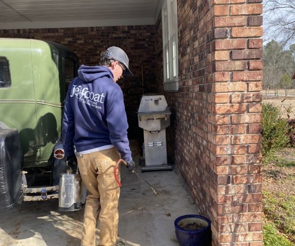 Jeffcoat tech applying pest defense barrier.